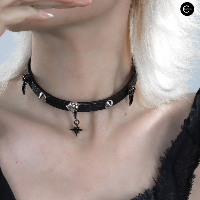A Part Of Me Raven Series black choker necklace with pointed studs and a star pendant shown worn around the neck