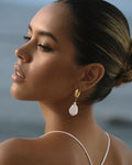 dark-skoinned model wearing dangle pearl earrings