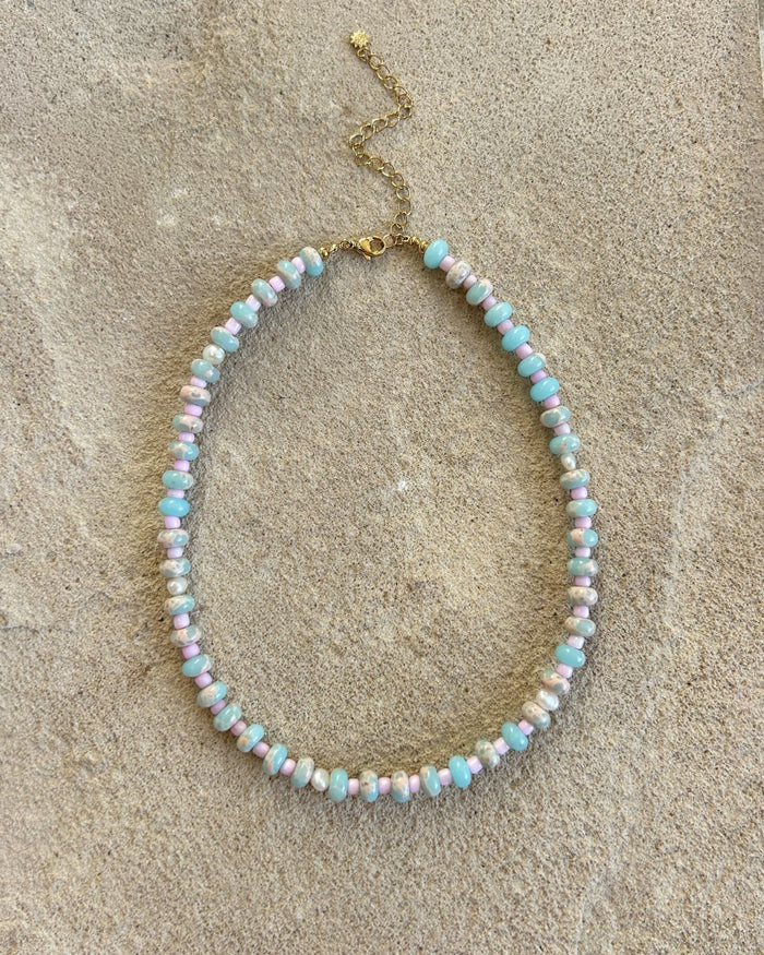 colorful beaded necklace on a textured beige surface
