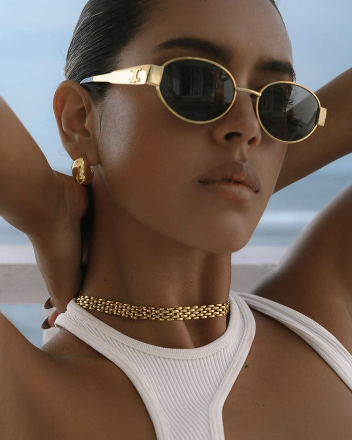 a dark-skinned girl wearing gold chain choker
