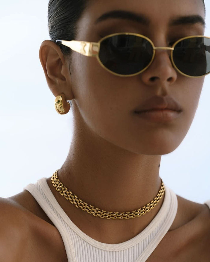 model wearing a chunky choker gold necklace