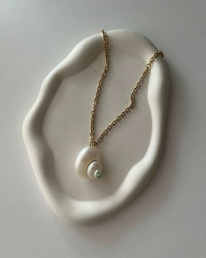 Pearl necklace on a white tray