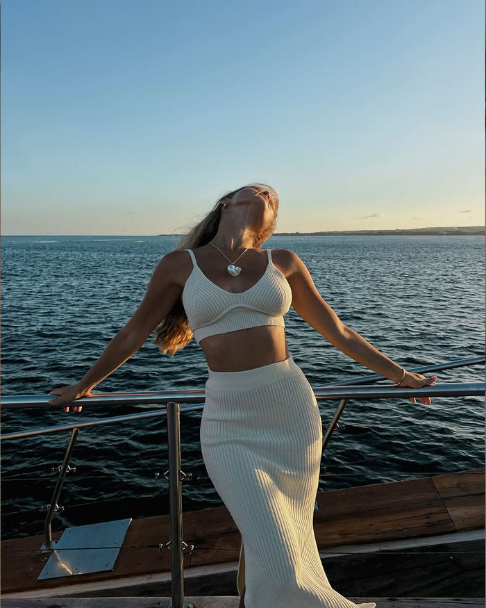 model standing posing with the bakcground of the sea wearing vacay outfit