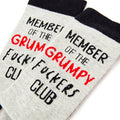 Close up of grumpy club slogan design on novelty socks with bold text