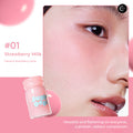 Judydoll Milky Blush Liquid #01 Strawberry Milk bottle beside a close-up cheek with pink blush