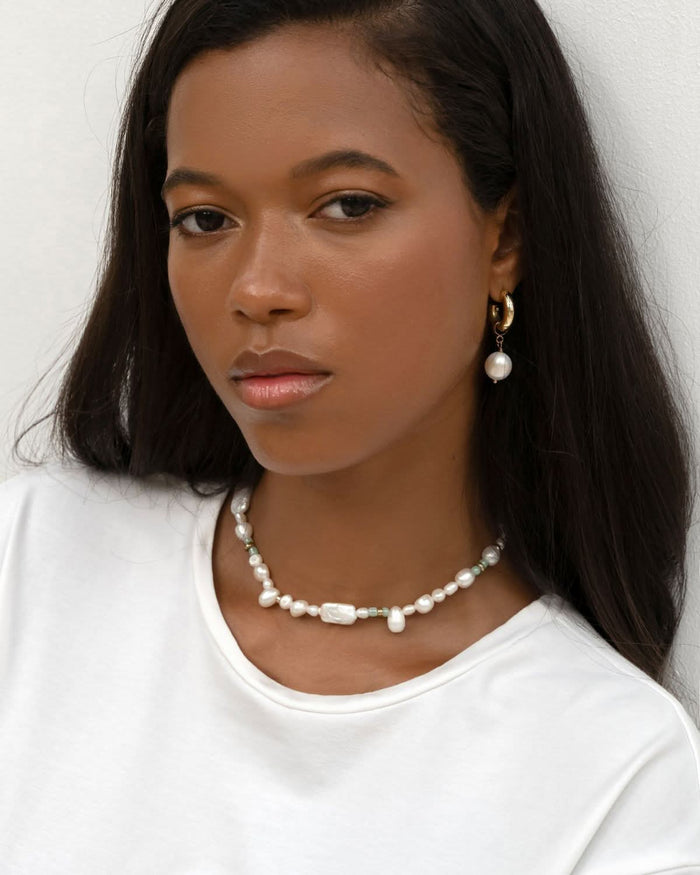 pearl necklace choker styled with white shirt on a dark skin model
