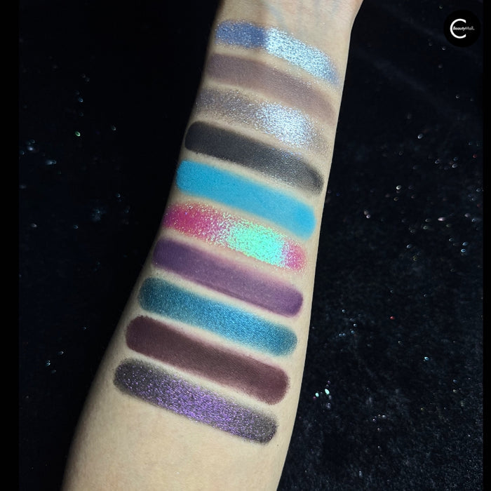 NOIRICORN SANCTUM BLOOM eyeshadow palette arm swatches displaying blue, purple, silver, and pink shades.