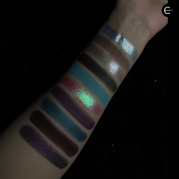 NOIRICORN SANCTUM BLOOM eyeshadow palette arm swatches showing shimmery and matte shades in blue, purple, green, and brown.