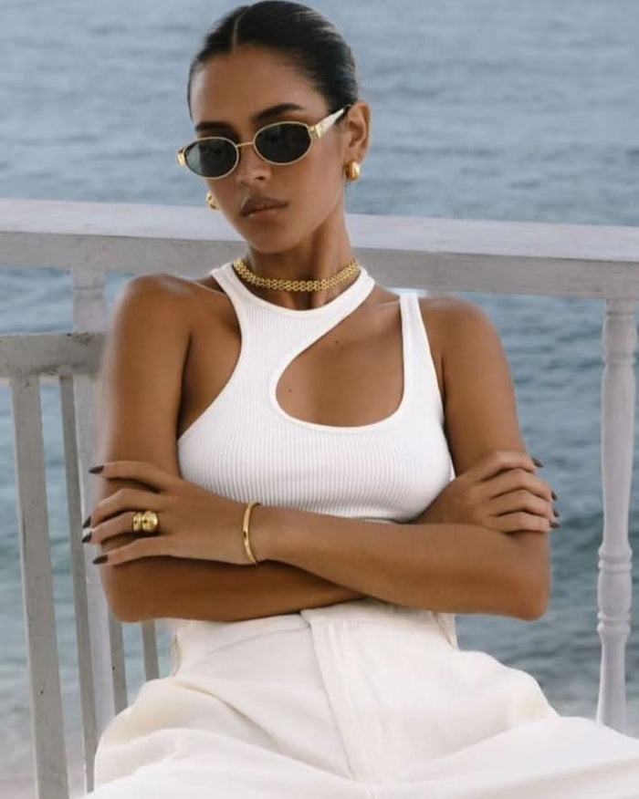 gold jewelry set styled with white top and wide leg trousers