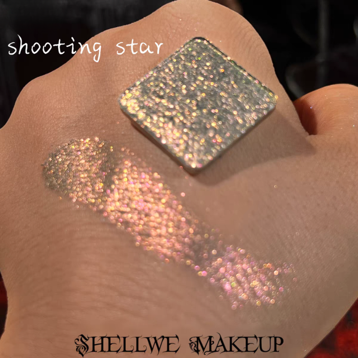 Shellwe Makeup Shooting Star single eyeshadow pan with glittery swatches on a hand