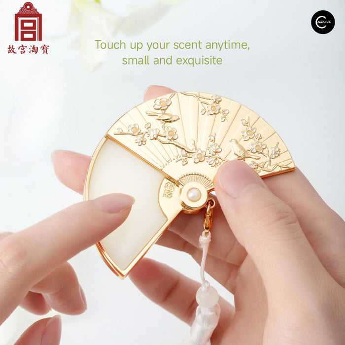 The Palace Museum folding fan solid perfume balm, shown open in hand