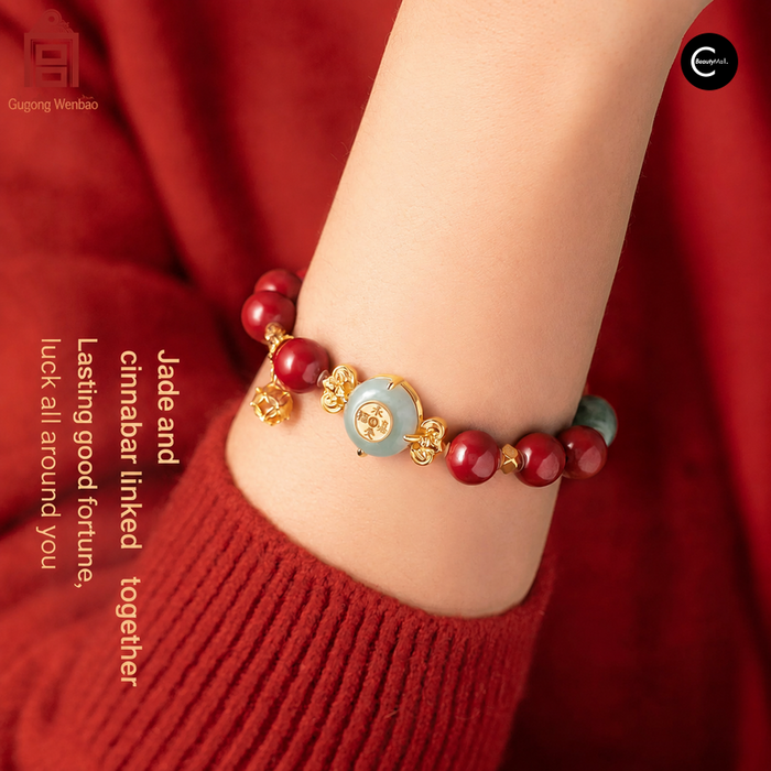 Gugong Wenbao red-bead bracelet with a pale green centerpiece, shown on a wrist