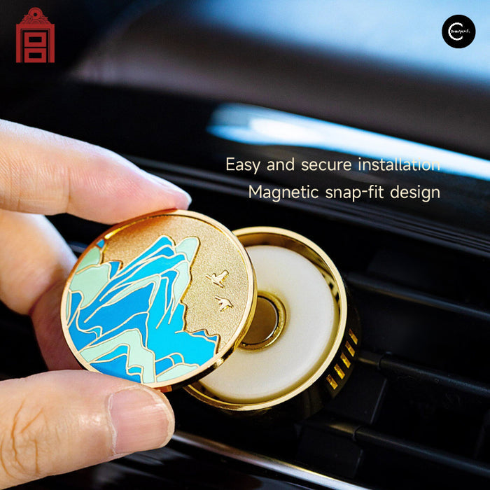 The Palace Museum car fragrance #01 with blue mountain-patterned gold cover shown near a car air vent